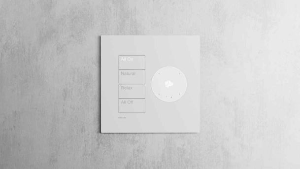 White smart lighting keypad with scene controls on a concrete wall